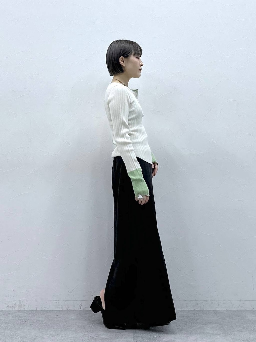 ブラック系のスカート、ホワイト系のニット/セーターを着用したレディースの春コーディネートの5枚目の写真