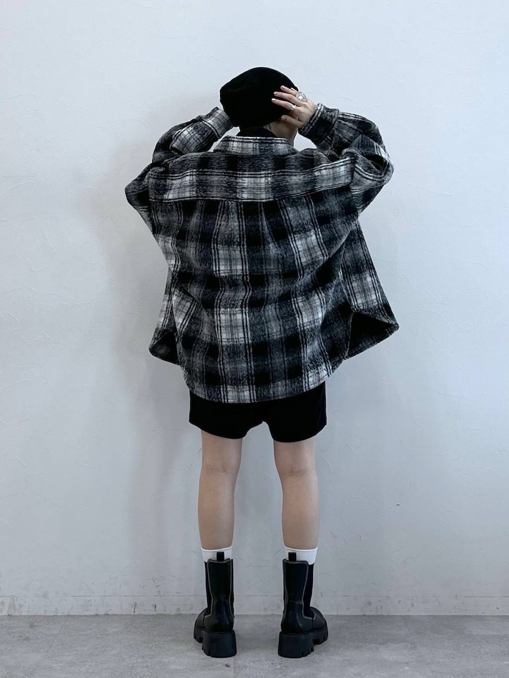 ブラック系のチノパンツ、ブラック系のブーツ、ブラック系のブルゾンを着用したレディースの冬コーディネートの5枚目の写真