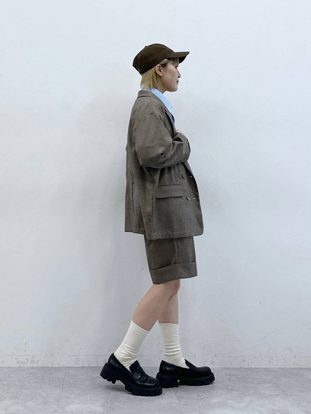 ブラック系のローファー、ブラウン系のスラックス、ブラウン系のテーラードジャケットを着用したレディースの夏コーディネートの4枚目の写真