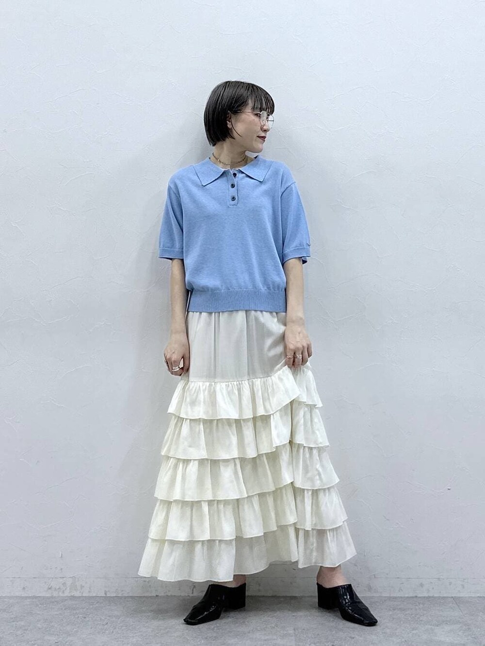 ブルー系のポロシャツ、ホワイト系のスカートを着用したレディースの春コーディネートの5枚目の写真