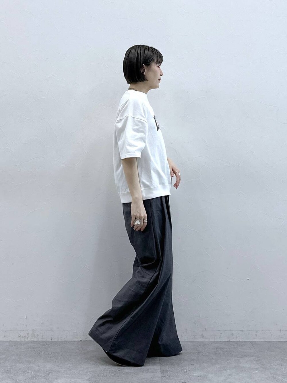 ホワイト系のTシャツ/カットソー、グレー系のスラックスを着用したレディースの春コーディネートの7枚目の写真