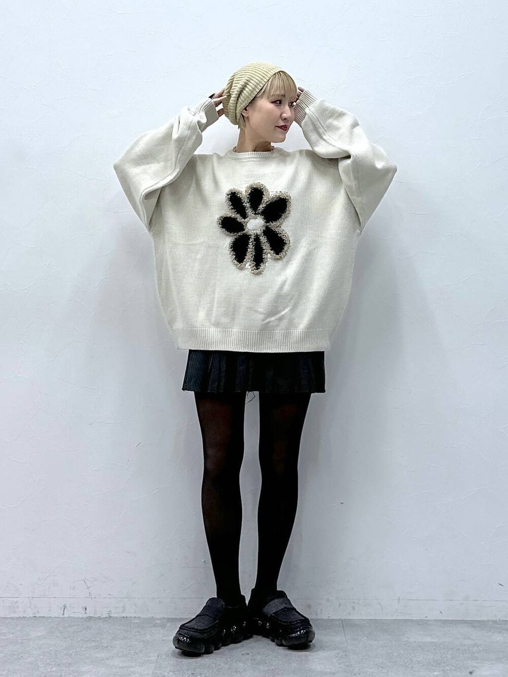 グレー系のスカート、ホワイト系のニット/セーター、ベージュ系のハンチング/ベレー帽を着用したレディースの冬コーディネートの6枚目の写真