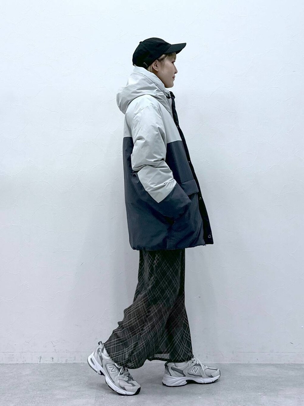 グレー系のダウンジャケット/コート、ブラック系のキャップを着用したレディースの冬コーディネートの4枚目の写真