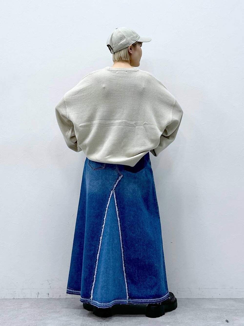 ブルー系のデニムスカート、ホワイト系のニット/セーター、ブラック系のローファーを着用したレディースの冬コーディネートの6枚目の写真