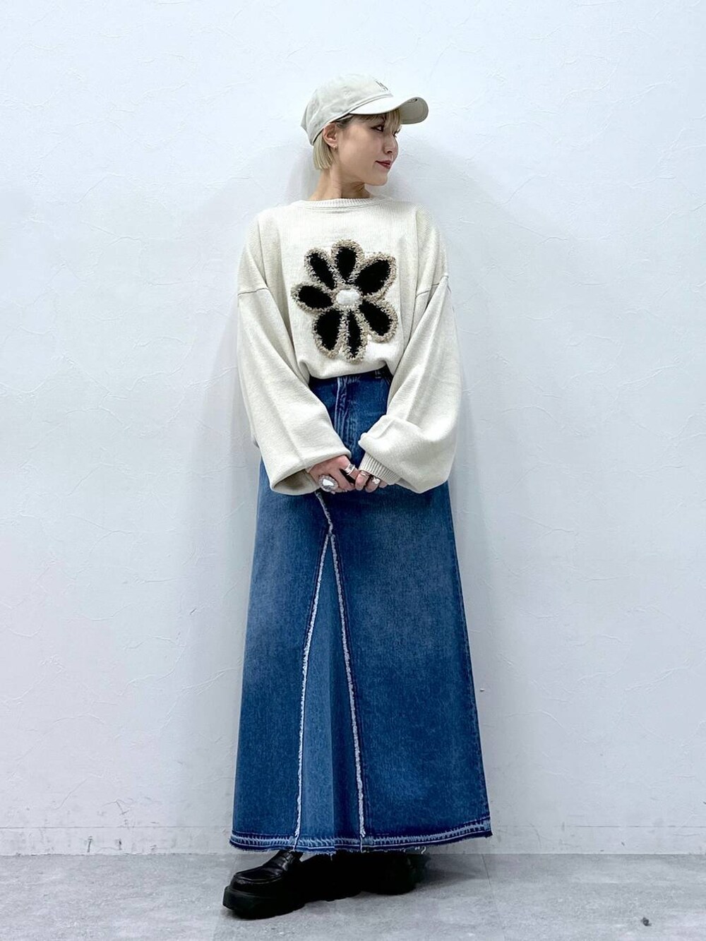 ブルー系のデニムスカート、ホワイト系のニット/セーター、ブラック系のローファーを着用したレディースの冬コーディネートの7枚目の写真