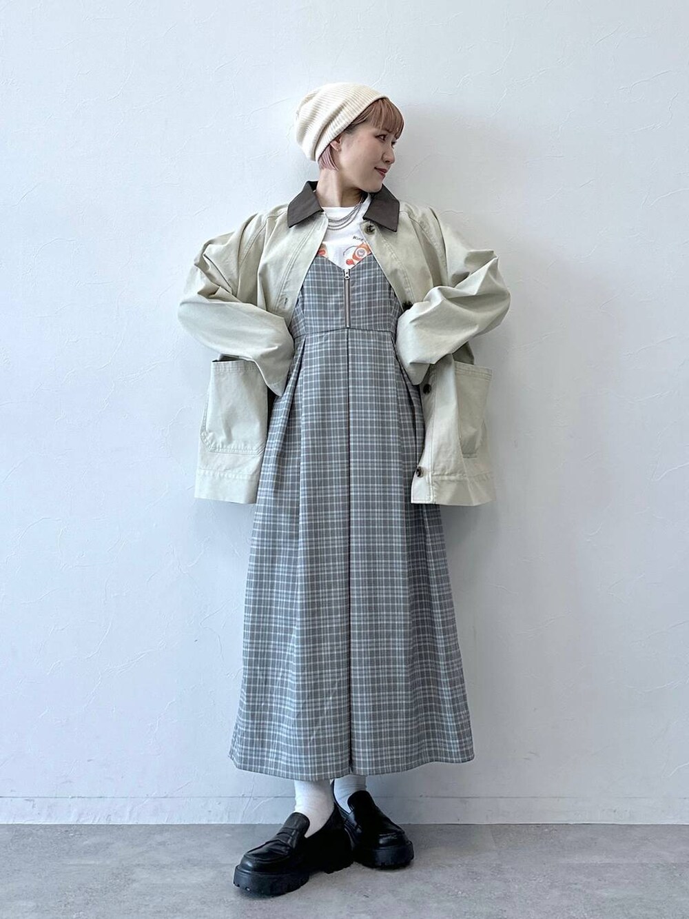 ブラック系のローファー、ホワイト系のブルゾン、グレー系のワンピースを着用したレディースの冬コーディネートの2枚目の写真