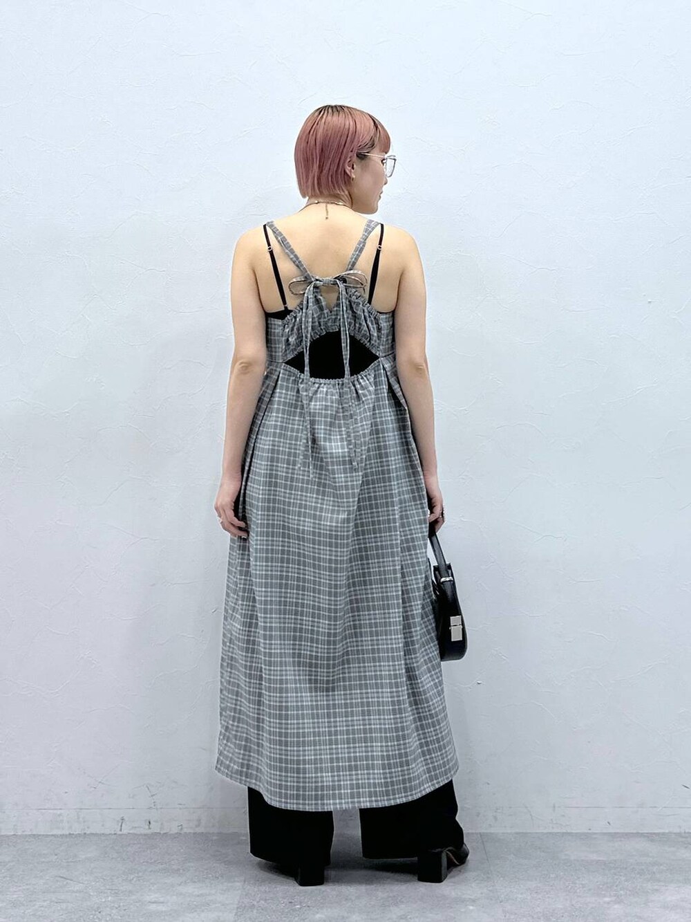 グレー系のワンピース、ブラック系のスラックスを着用したレディースの春コーディネートの5枚目の写真