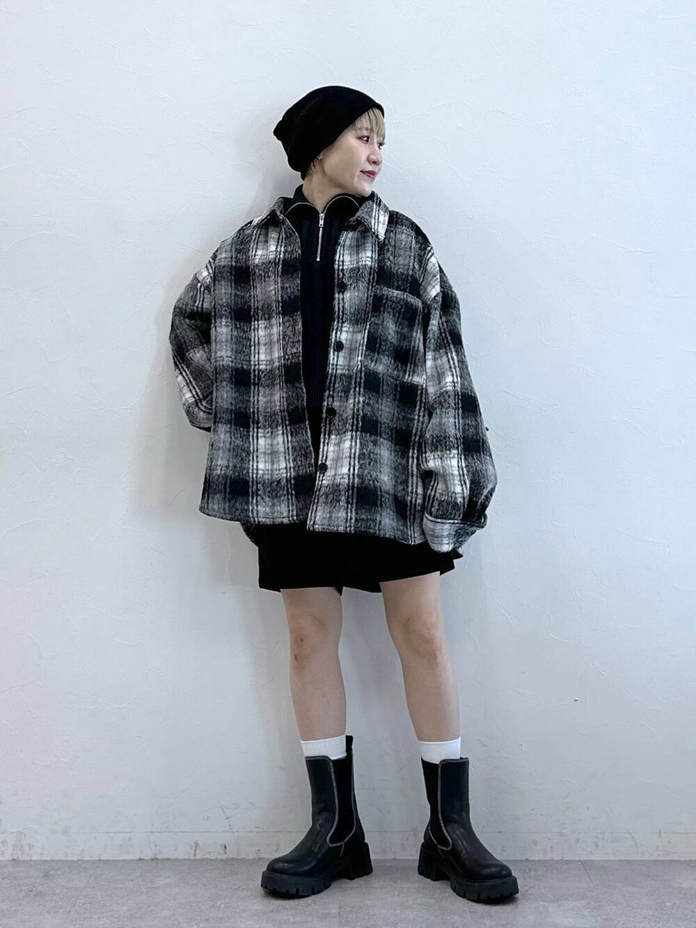 ブラック系のチノパンツ、ブラック系のブーツ、ブラック系のブルゾンを着用したレディースの冬コーディネートの3枚目の写真