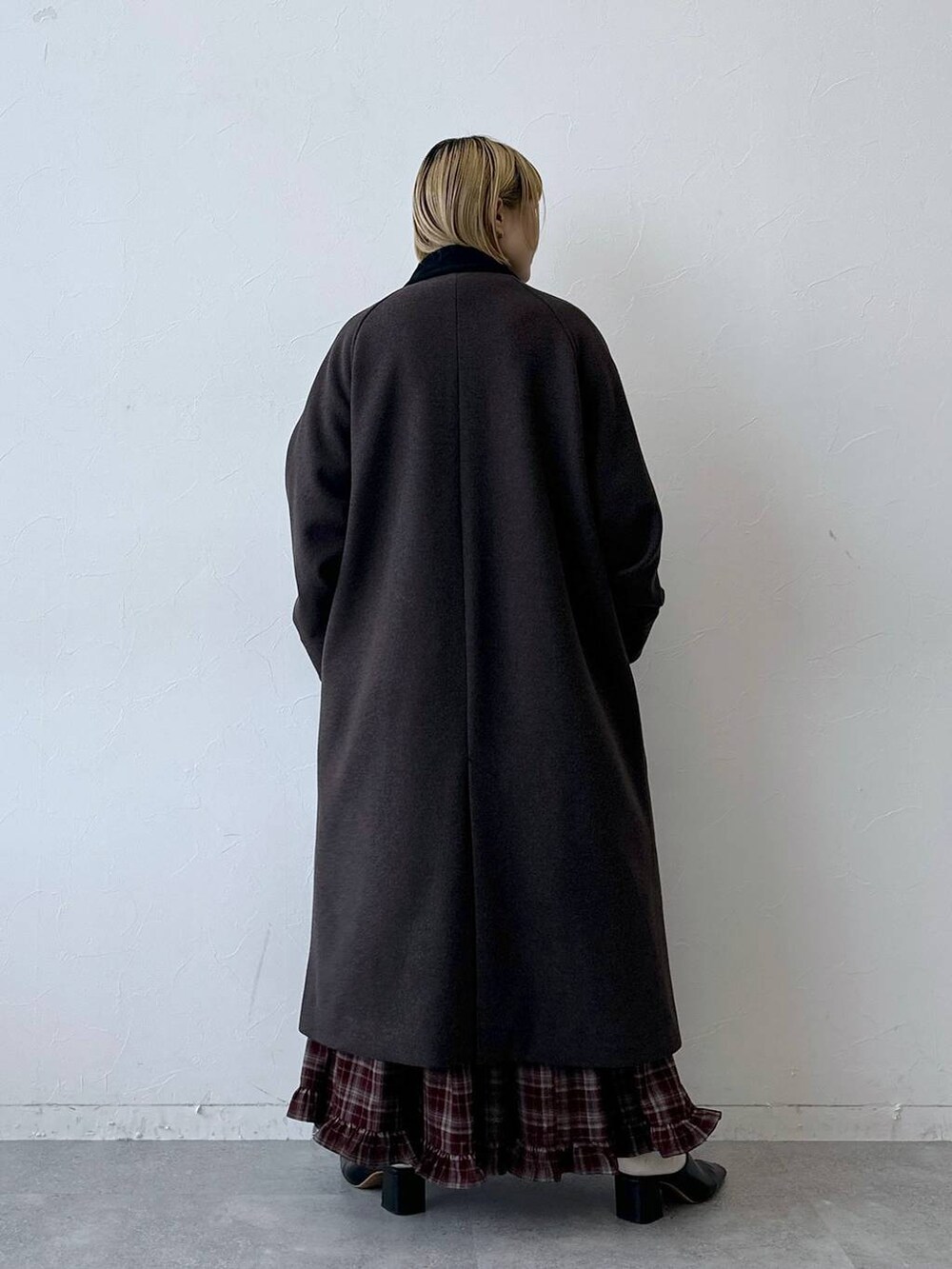 ブラウン系のステンカラーコート、レッド系のスカートを着用したレディースの秋コーディネートの5枚目の写真