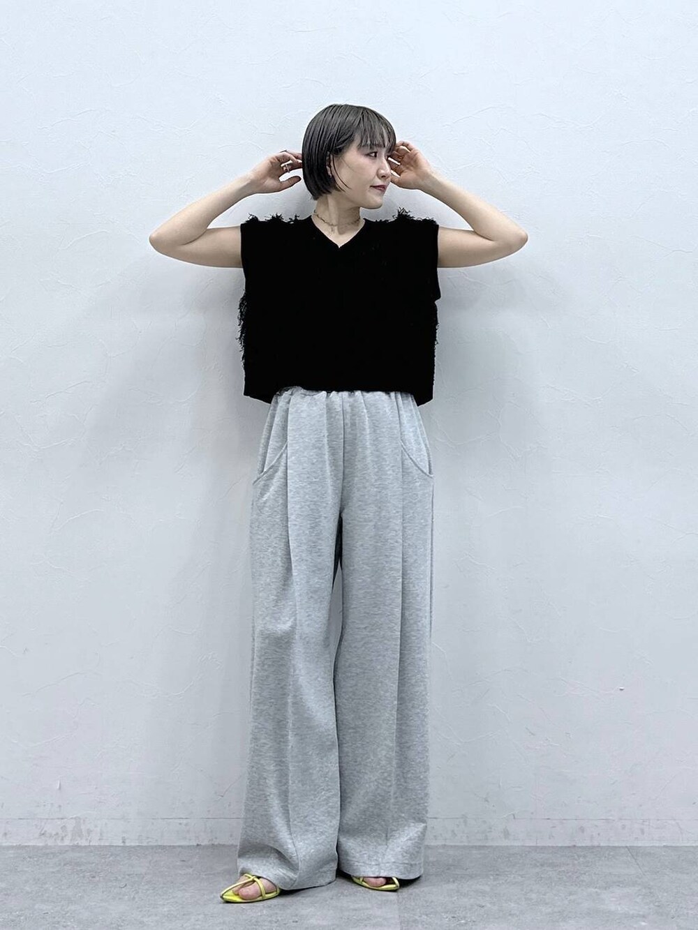 グレー系のスウェットパンツ、ブラック系のベストを着用したレディースの春コーディネートの4枚目の写真