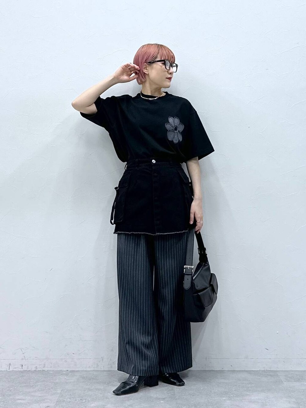 グレー系のスラックス、ブラック系のTシャツ/カットソー、ブラック系のスカートを着用したレディースの春コーディネートの3枚目の写真