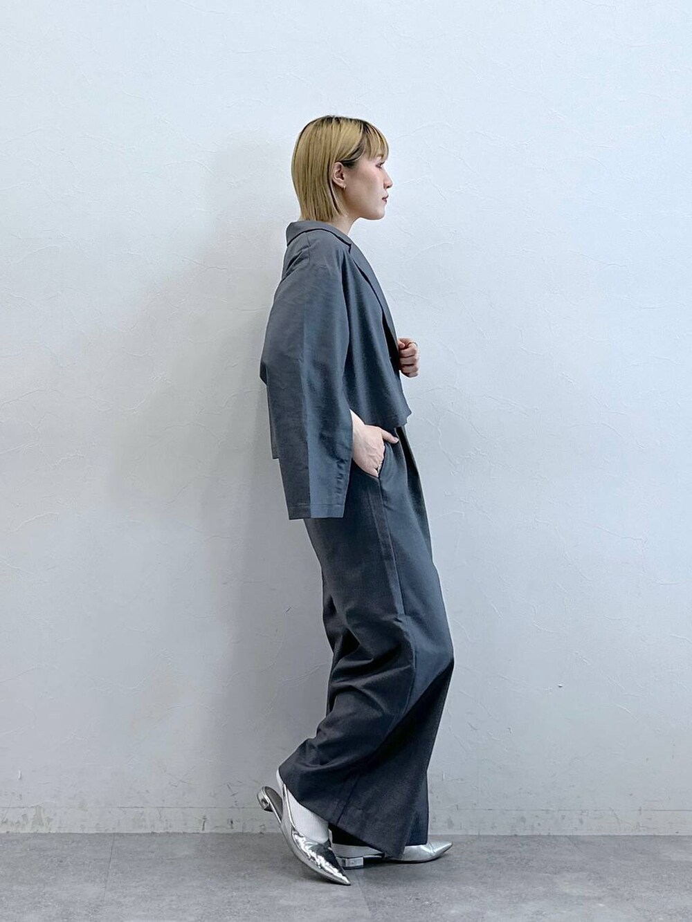 グレー系のテーラードジャケットを着用したレディースの夏コーディネートの5枚目の写真