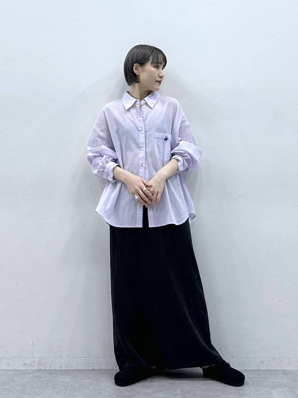 パープル系のシャツ/ブラウス、ブラック系のモカシン/デッキシューズ、ブラック系のスカートを着用したレディースの春コーディネートの4枚目の写真