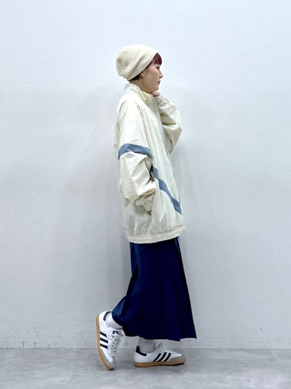 ホワイト系のブルゾン、ブルー系のスカートを着用したレディースの春コーディネートの4枚目の写真