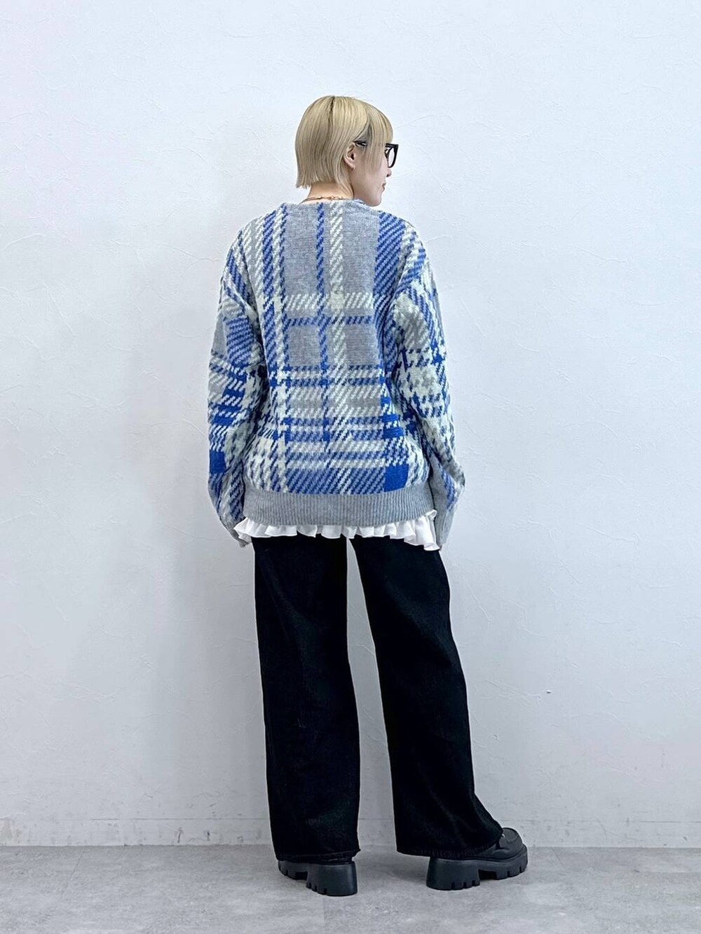 ブラック系のデニムパンツ、ブラック系のローファー、グレー系のニット/セーターを着用したレディースの秋コーディネートの5枚目の写真