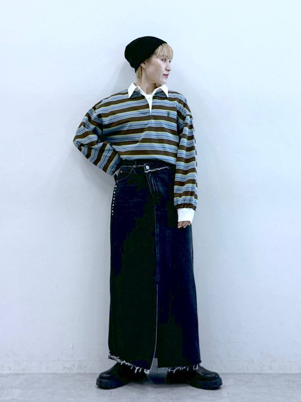 ブラック系のブーツ、ブラック系のデニムスカート、ブラウン系のポロシャツを着用したレディースの冬コーディネートの2枚目の写真