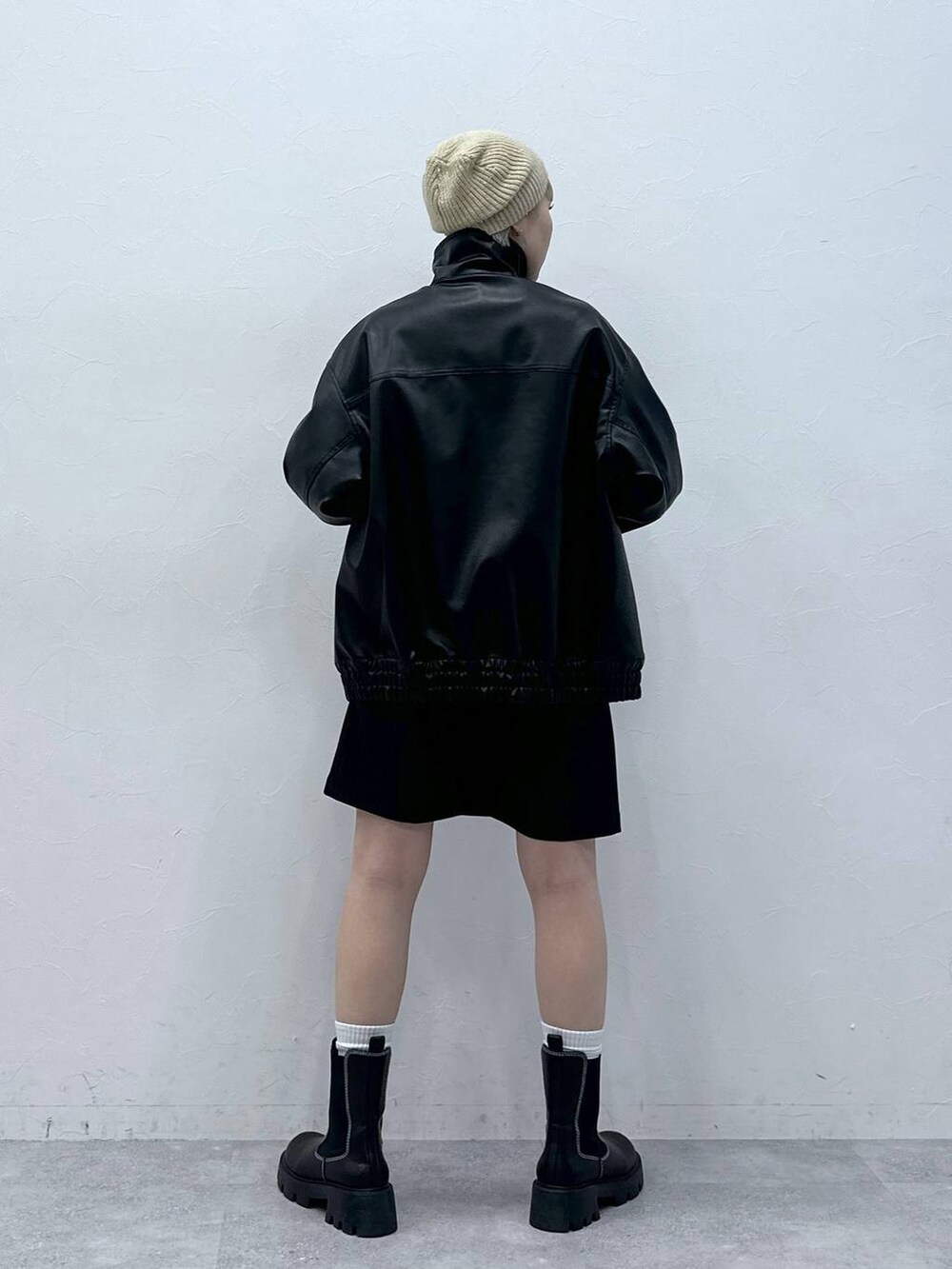 ブラック系のブーツ、ブラック系のスカート、ブラック系のブルゾンを着用したレディースの秋コーディネートの5枚目の写真