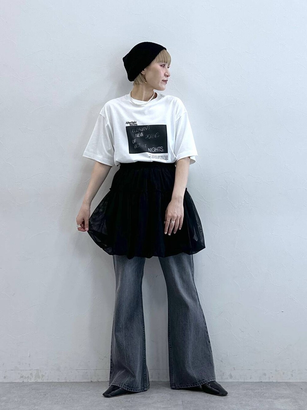 グレー系のデニムパンツ、ブラック系のスカート、ブラック系のニットキャップ/ビーニーを着用したレディースの夏コーディネートの3枚目の写真