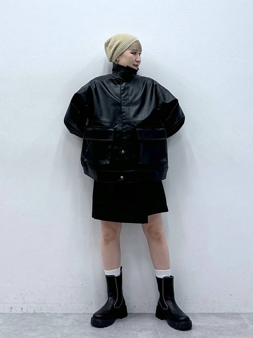 ブラック系のブーツ、ホワイト系のTシャツ/カットソー、ブラック系のスカートを着用したレディースの秋コーディネートの6枚目の写真