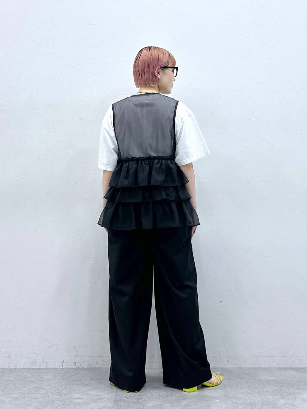 ブラック系のスラックス、ホワイト系のTシャツ/カットソー、ブラック系のベストを着用したレディースの春コーディネートの5枚目の写真