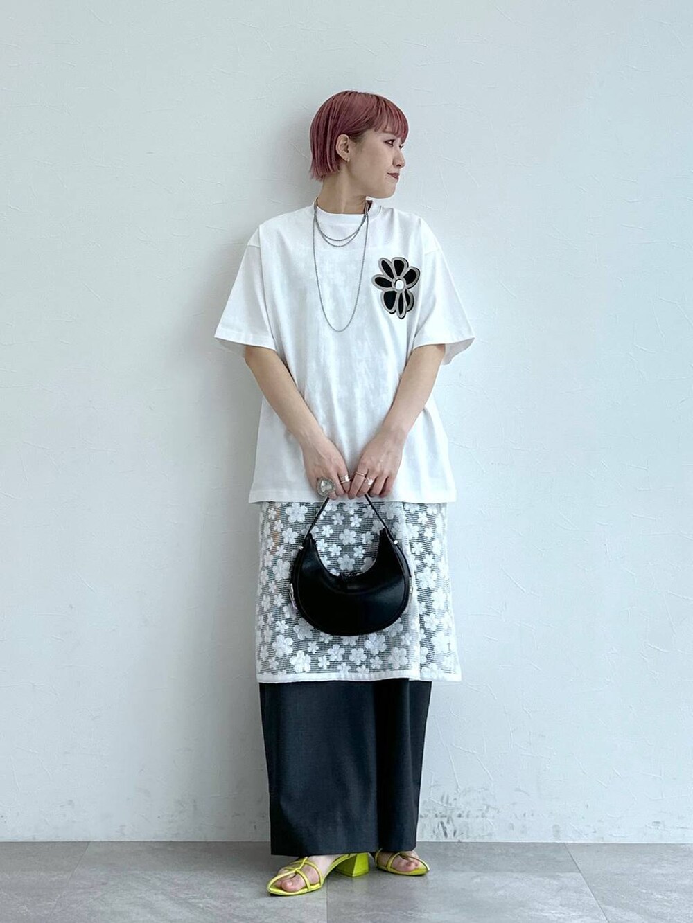 グレー系のスラックス、ホワイト系のワンピース、ホワイト系のTシャツ/カットソーを着用したレディースの春コーディネートの2枚目の写真
