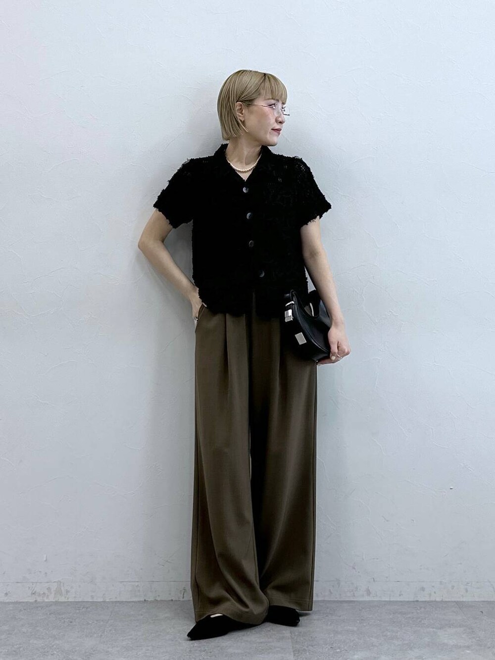 ブラック系のシャツ/ブラウス、ブラウン系のスラックスを着用したレディースの夏コーディネートの3枚目の写真