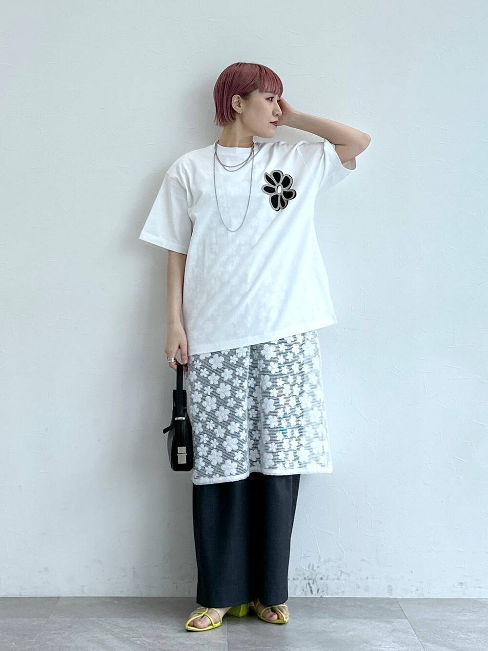 グレー系のスラックス、ホワイト系のワンピース、ホワイト系のTシャツ/カットソーを着用したレディースの春コーディネートの3枚目の写真