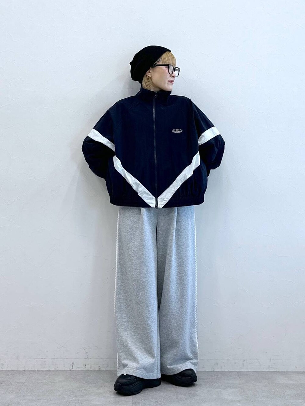 グレー系のスウェットパンツ、ブルー系のブルゾン、ブラック系のニットキャップ/ビーニーを着用したレディースの夏コーディネートの3枚目の写真