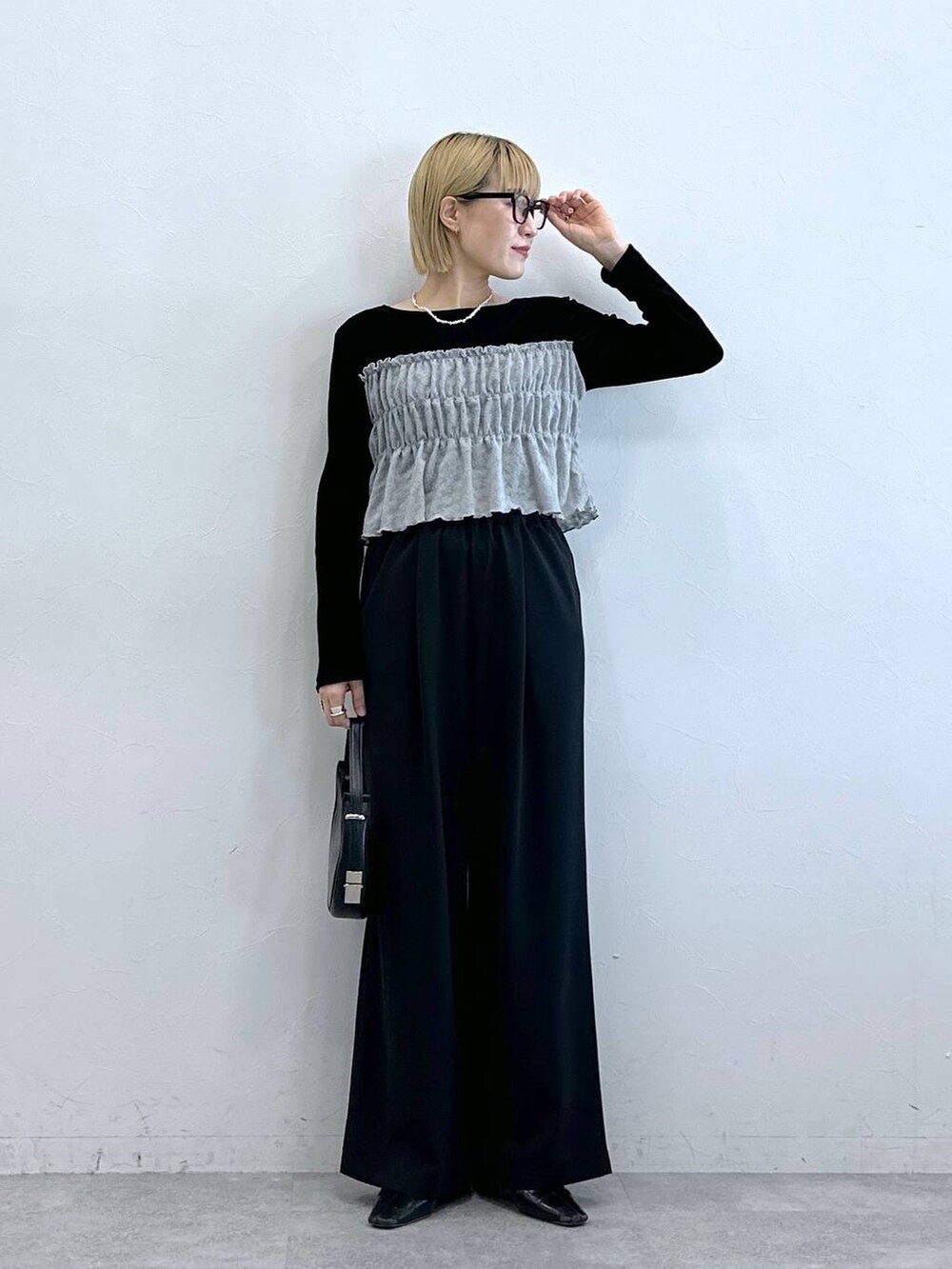 ブラック系のスラックス、ブラック系のTシャツ/カットソー、グレー系のメガネを着用したレディースの夏コーディネートの2枚目の写真