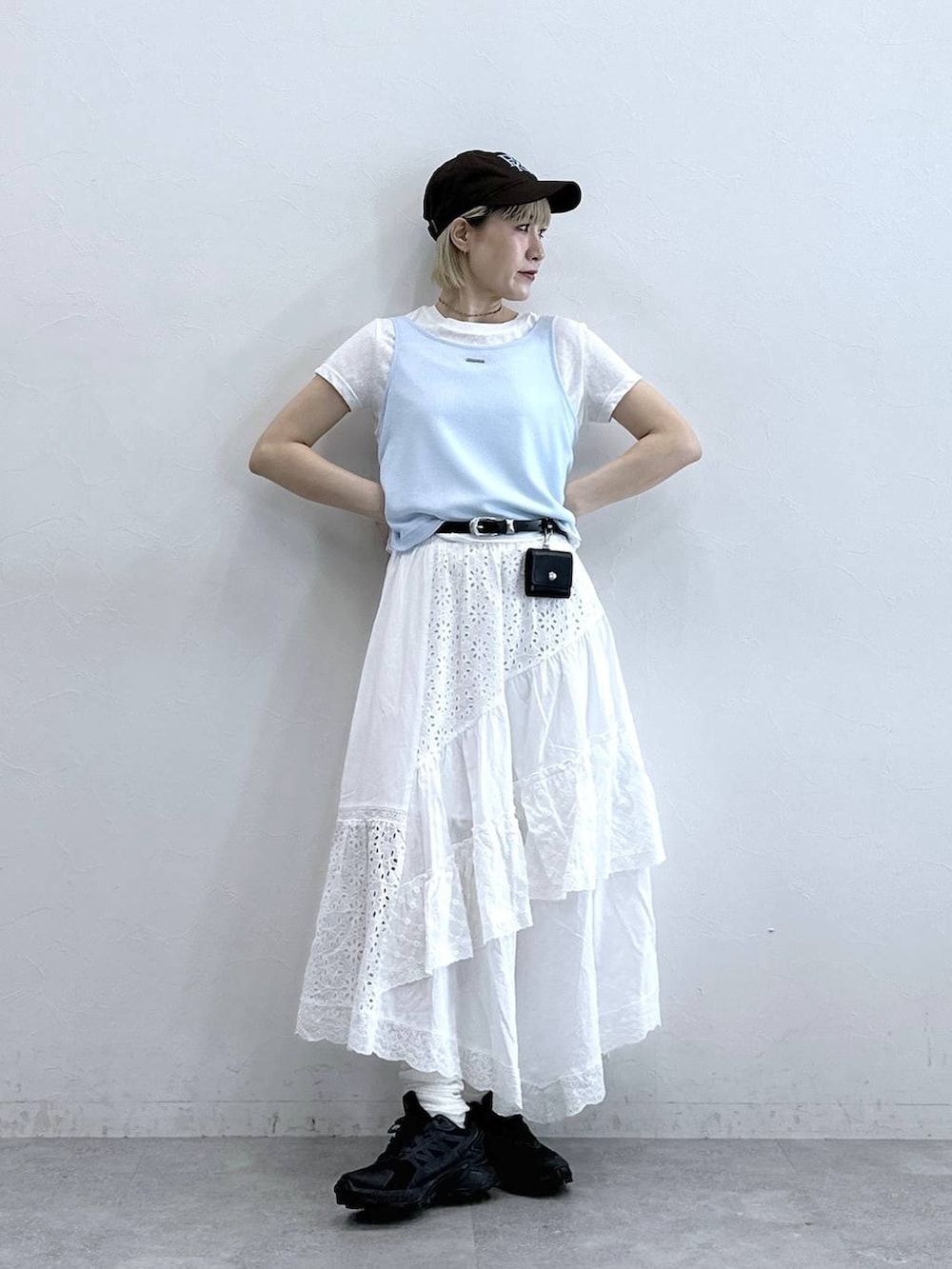 ホワイト系のスカート、ホワイト系のTシャツ/カットソー、ブラウン系のキャップを着用したレディースの夏コーディネートの2枚目の写真
