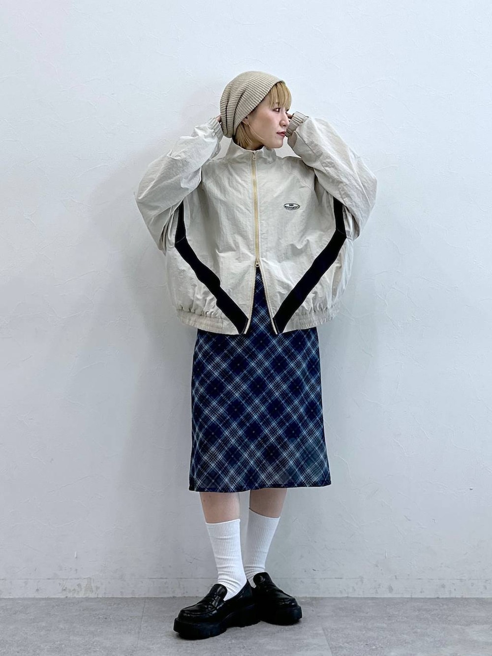 ブラック系のローファー、ブルー系のスカート、ホワイト系のブルゾンを着用したレディースの夏コーディネートの3枚目の写真