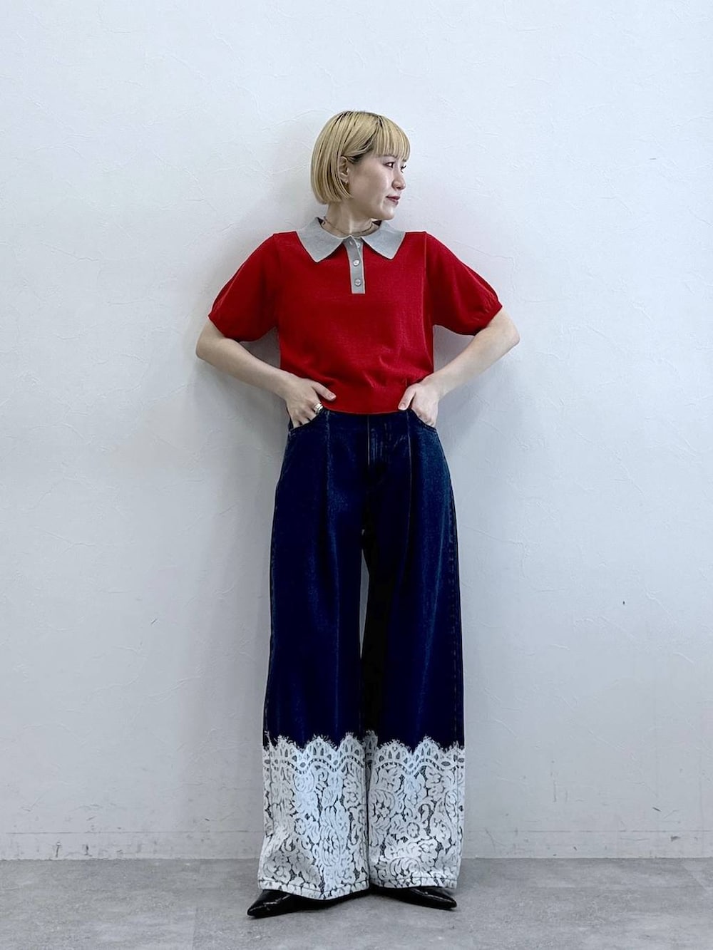 ブルー系のデニムパンツ、レッド系のポロシャツを着用したレディースの春コーディネートの3枚目の写真