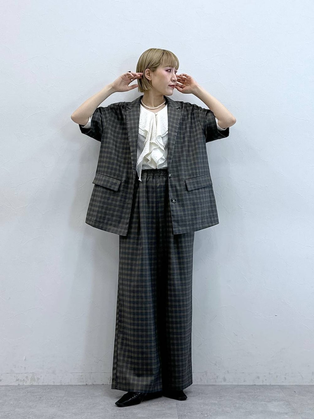 ホワイト系のシャツ/ブラウス、イエロー系のテーラードジャケット、イエロー系のスラックスを着用したレディースの夏コーディネートの3枚目の写真