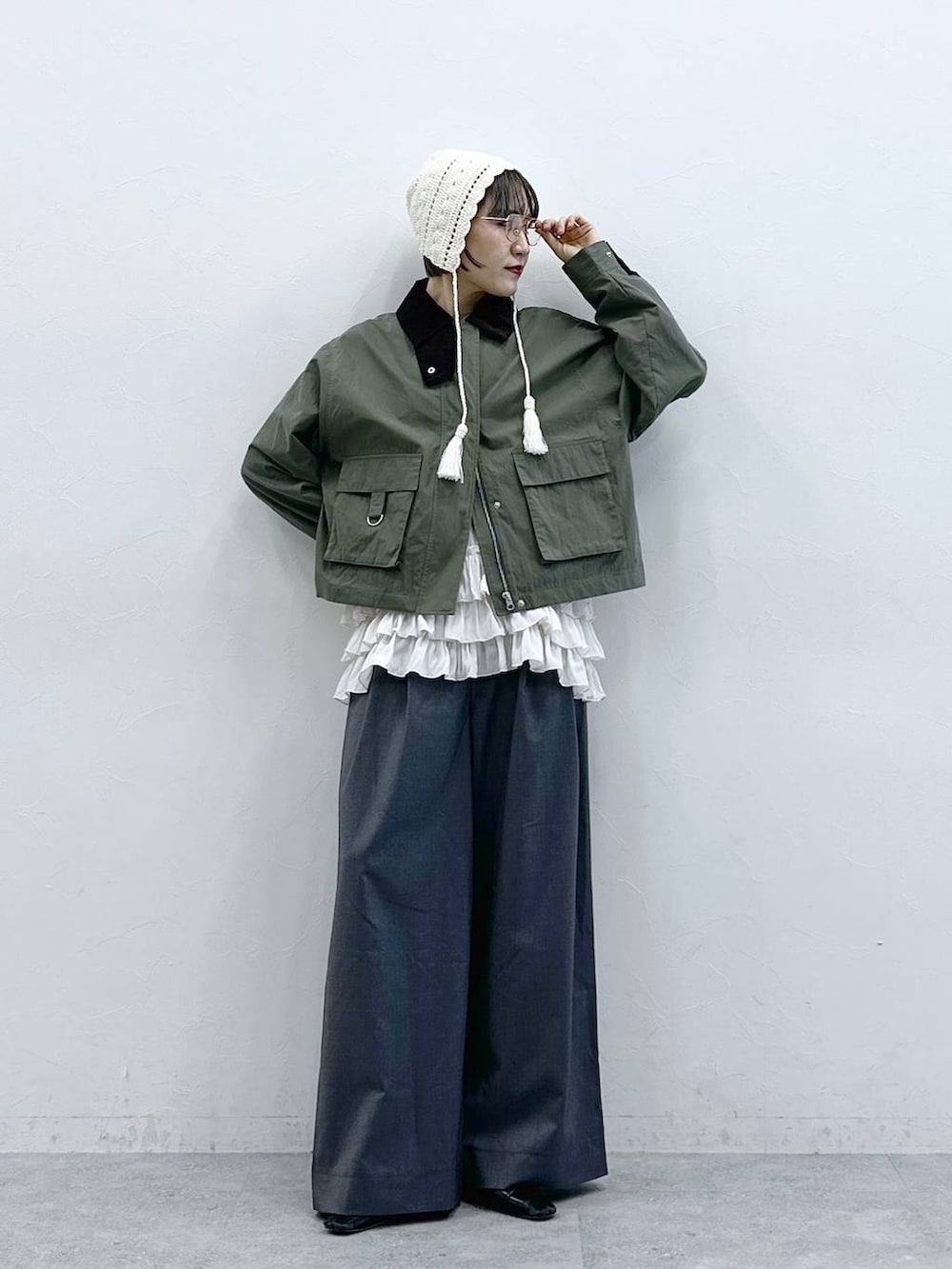 ホワイト系のキャミソール、グリーン系のブルゾン、グレー系のスラックスを着用したレディースの春コーディネートの4枚目の写真