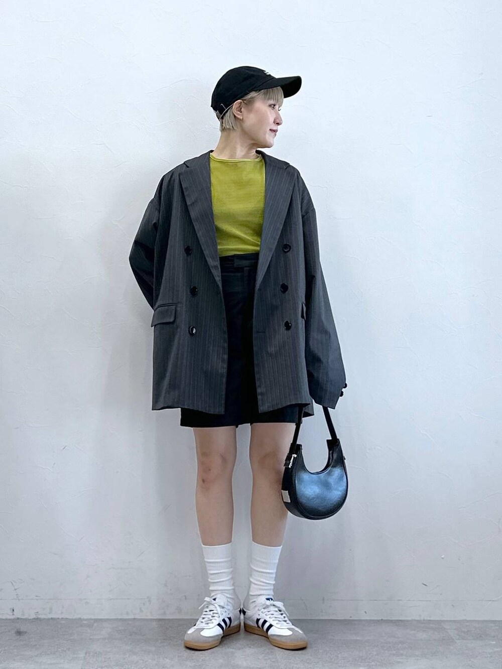 ブラック系のチノパンツ、グリーン系のTシャツ/カットソー、グレー系のテーラードジャケットを着用したレディースの冬コーディネートの5枚目の写真