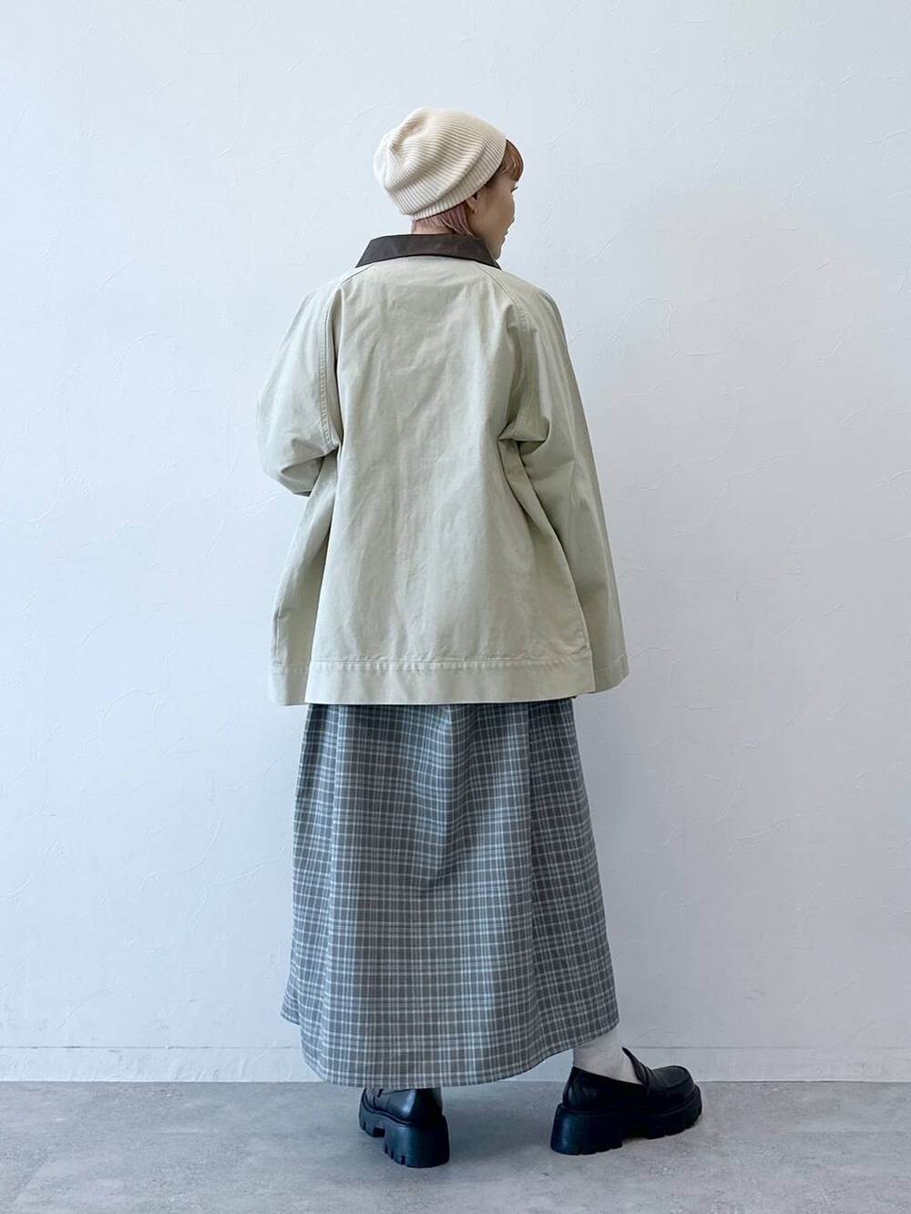 ブラック系のローファー、ホワイト系のブルゾン、グレー系のワンピースを着用したレディースの冬コーディネートの6枚目の写真