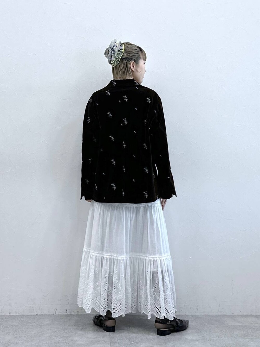 ブラック系のパンプス、ブラック系のテーラードジャケット、ホワイト系のスカートを着用したレディースの冬コーディネートの5枚目の写真