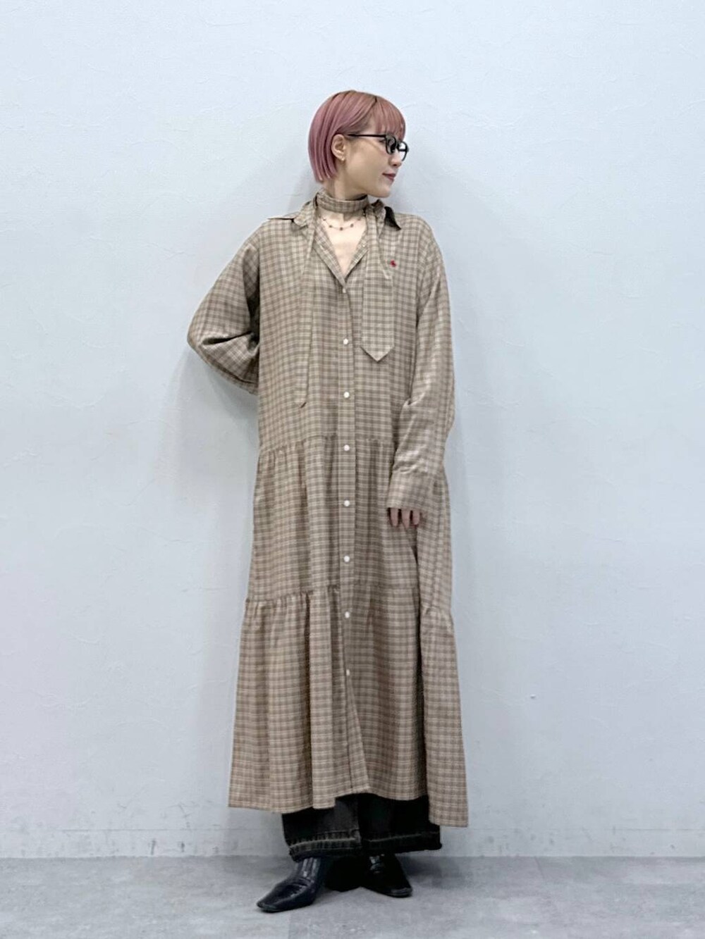 ブラック系のデニムパンツ、ベージュ系のワンピースを着用したレディースの冬コーディネートの3枚目の写真