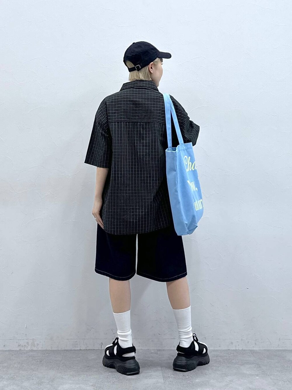 ブラック系のサンダル、ブルー系のデニムパンツ、ピンク系のトートバッグを着用したレディースの夏コーディネートの7枚目の写真