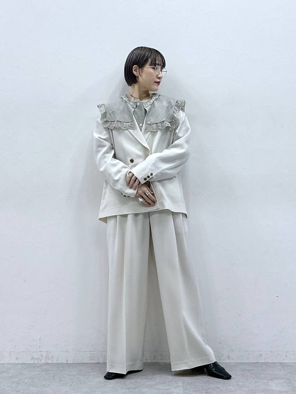 グリーン系のシャツ/ブラウス、ホワイト系のテーラードジャケット、ホワイト系のスラックスを着用したレディースの春コーディネートの2枚目の写真