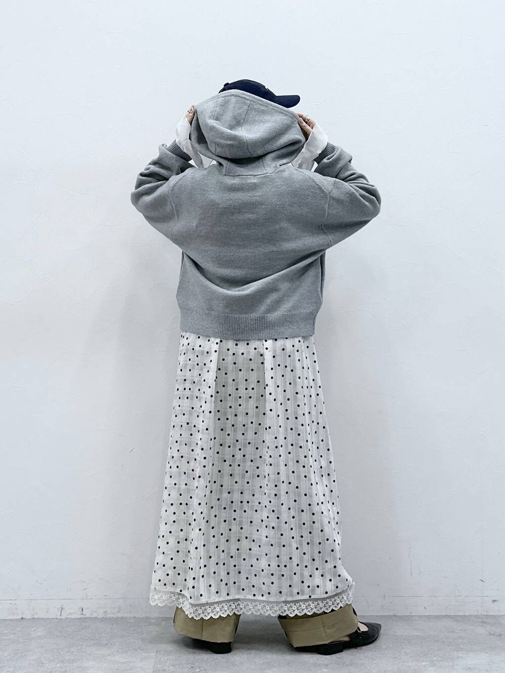 ブラック系のパンプス、グレー系のニット/セーター、ベージュ系のチノパンツを着用したレディースの冬コーディネートの5枚目の写真