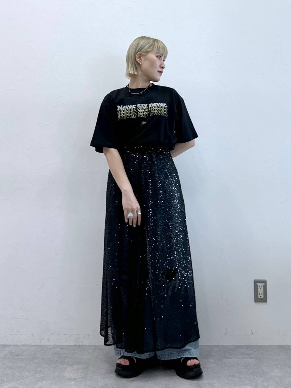 ブルー系のデニムパンツ、ブラック系のサンダル、ブラック系のTシャツ/カットソーを着用したレディースの夏コーディネートの3枚目の写真