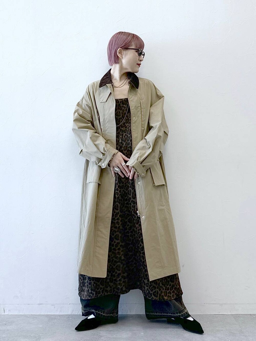 ベージュ系のステンカラーコート、ブラウン系のワンピースを着用したレディースの冬コーディネートの2枚目の写真