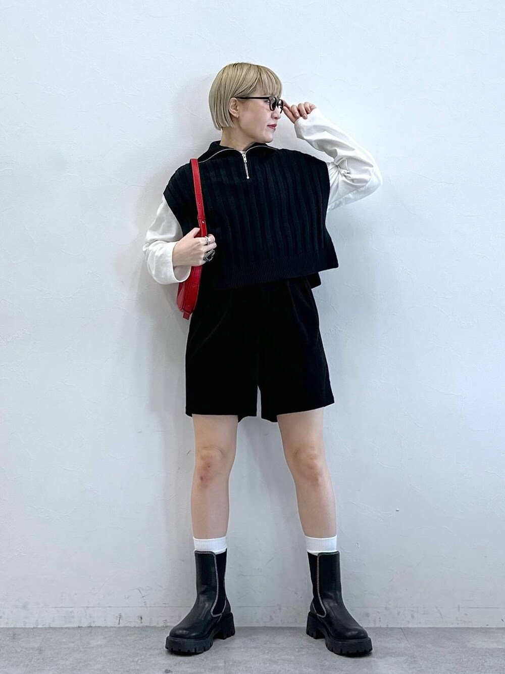 ブラック系のチノパンツ、レッド系のショルダーバッグ、ホワイト系のTシャツ/カットソーを着用したレディースの冬コーディネートの4枚目の写真