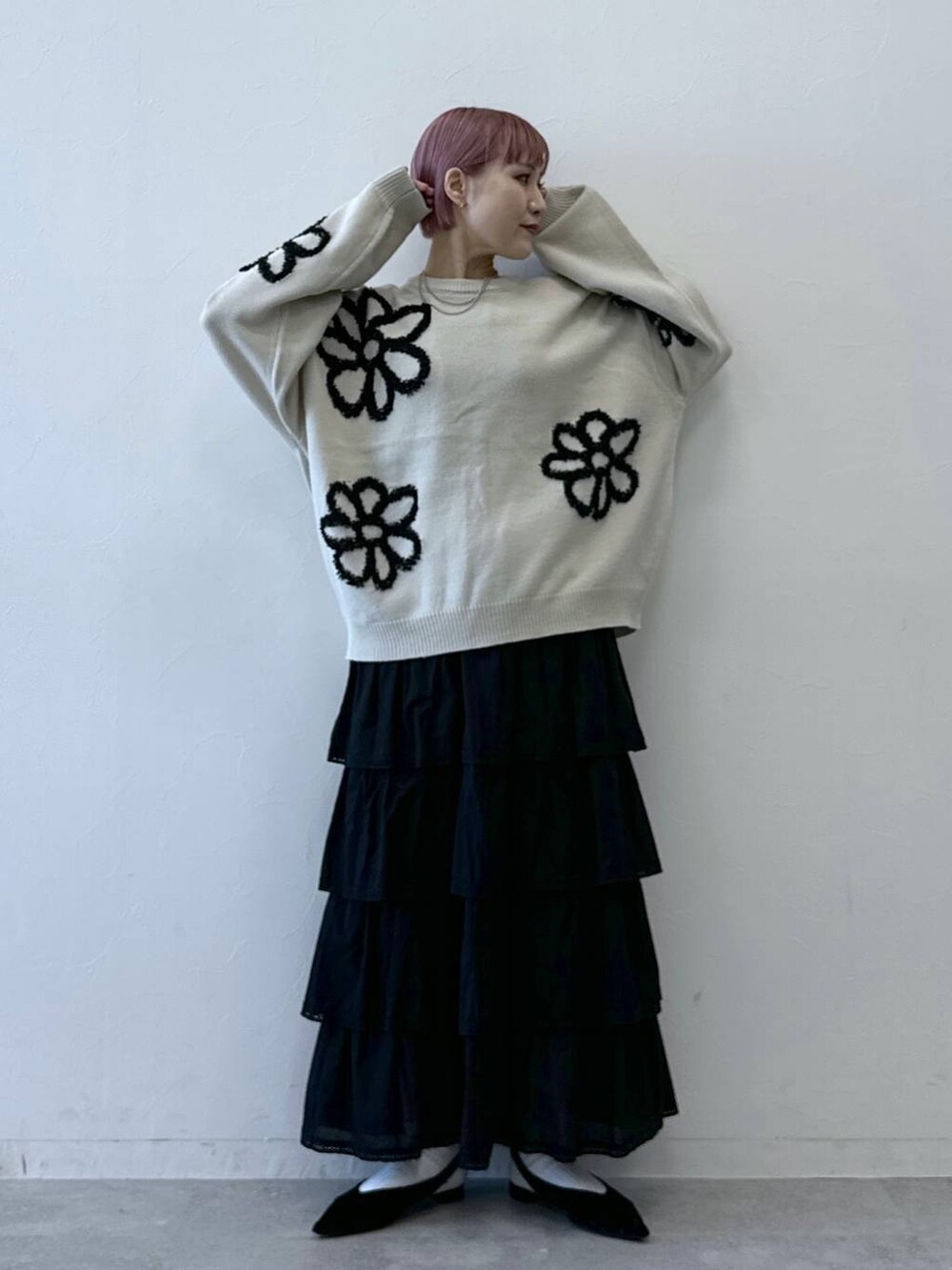 ブラック系のスカート、ホワイト系のニット/セーターを着用したレディースの冬コーディネートの2枚目の写真