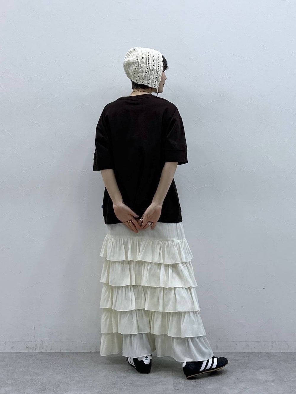 ブラウン系のTシャツ/カットソー、ホワイト系のスカート、ホワイト系のニットキャップ/ビーニーを着用したレディースの春コーディネートの6枚目の写真