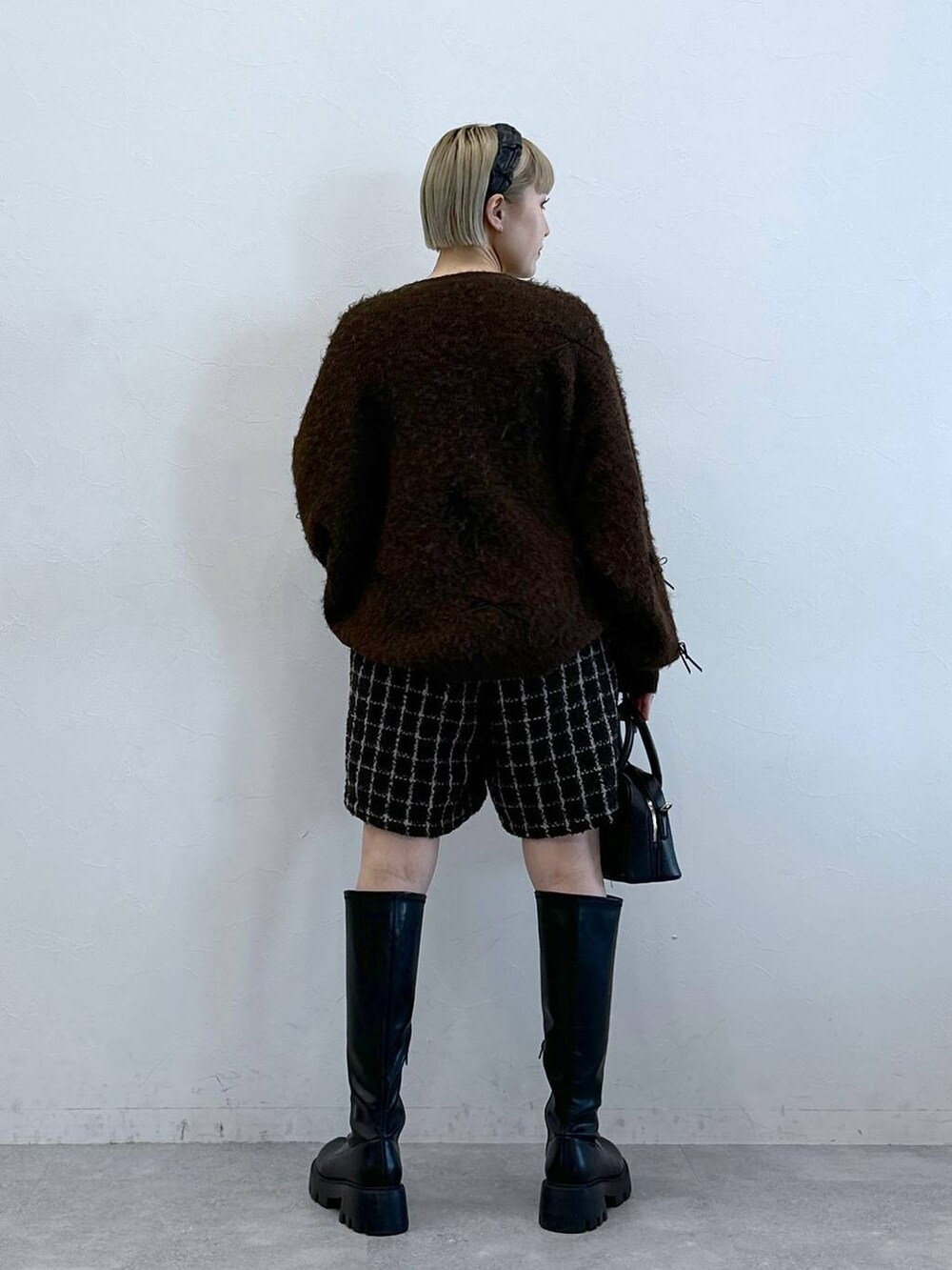 ブラック系のブーツ、ブラウン系のその他パンツ、ブラウン系のニット/セーターを着用したレディースの冬コーディネートの5枚目の写真