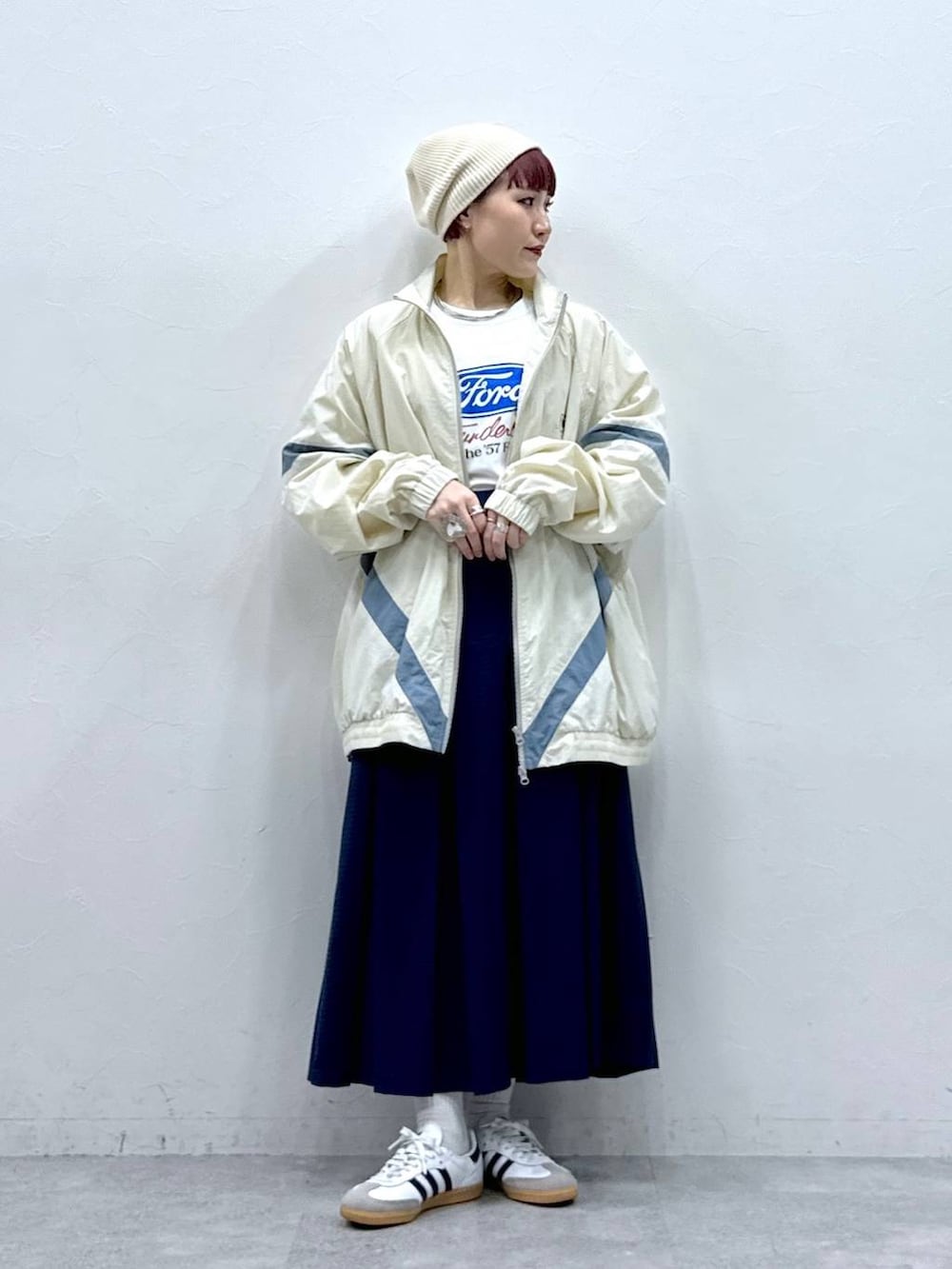 ホワイト系のブルゾン、ブルー系のスカートを着用したレディースの春コーディネートの2枚目の写真
