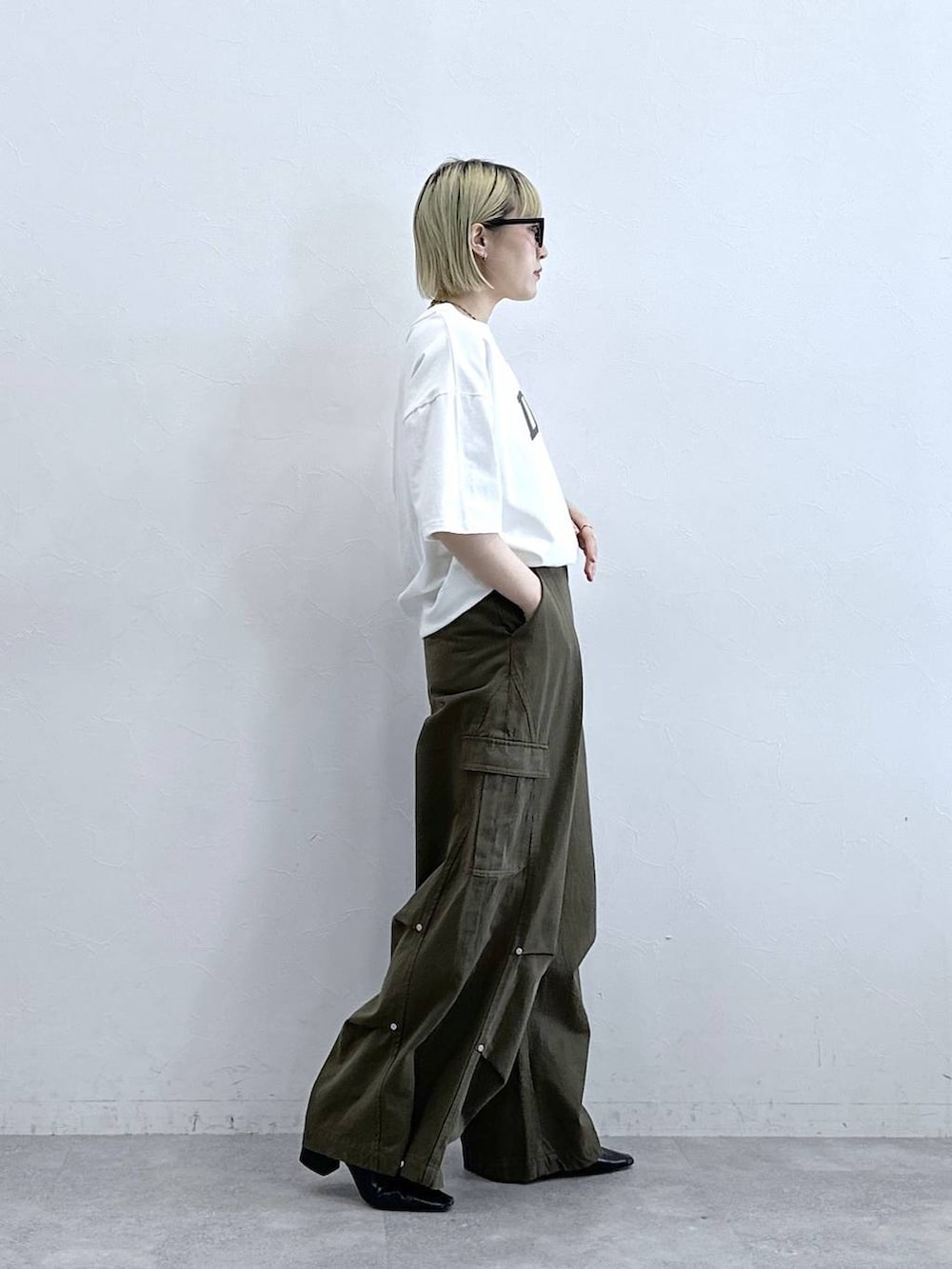 グリーン系のカーゴパンツ、ホワイト系のTシャツ/カットソーを着用したレディースの夏コーディネートの5枚目の写真