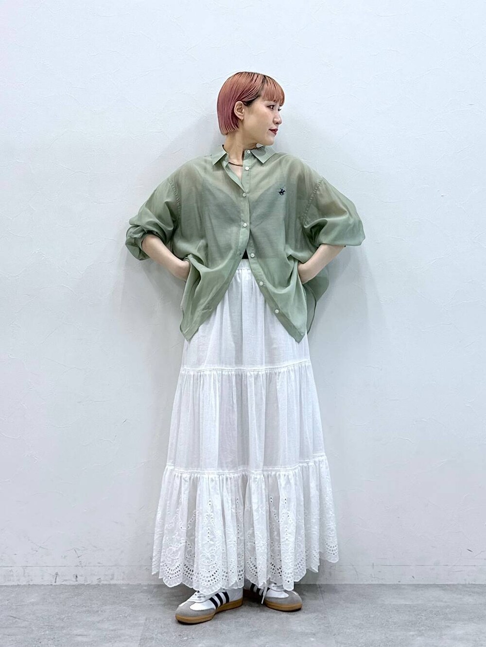 ホワイト系のスカート、グリーン系のシャツ/ブラウスを着用したレディースの春コーディネートの2枚目の写真